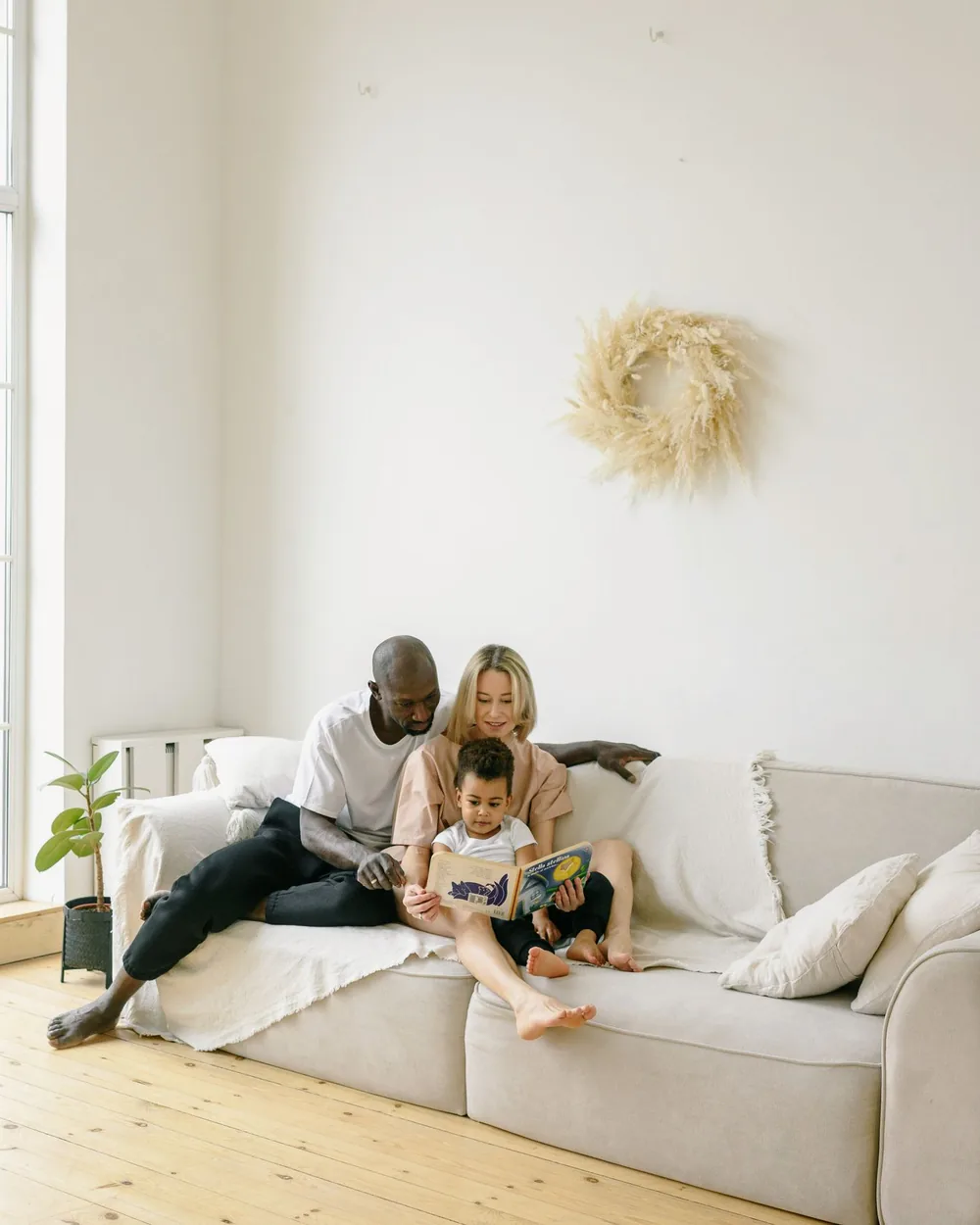 A family relaxing together on the sofa in a bright, clean living room