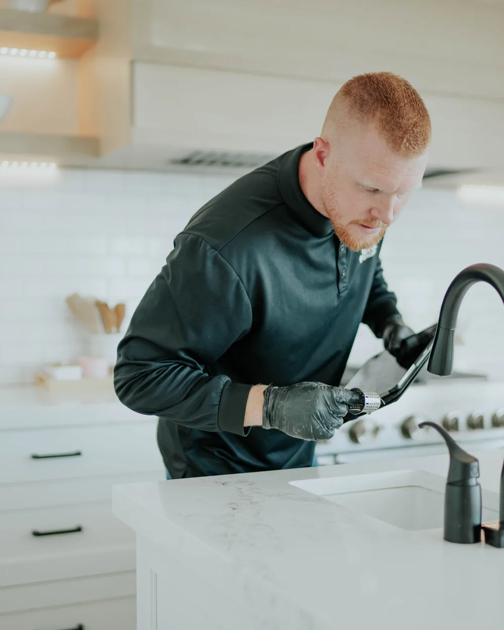 A Pure Maintenance technician inspecting a kitchen sink during a mold inspection